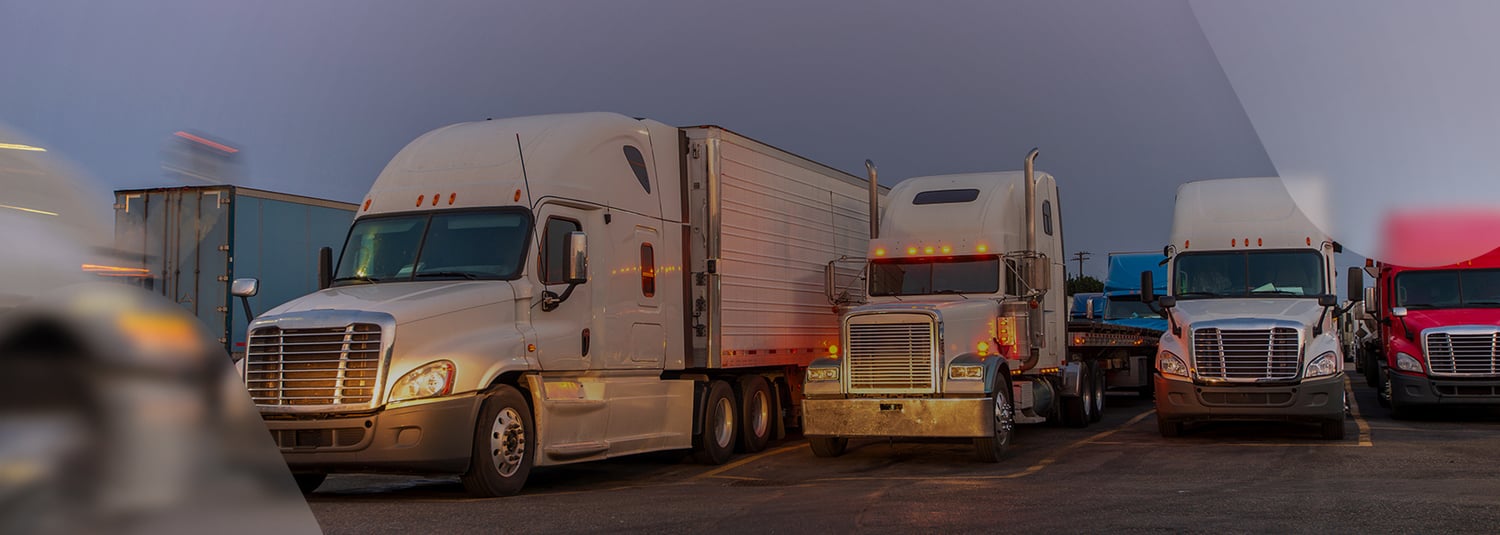 Commercial semi-trucks with trailers parked